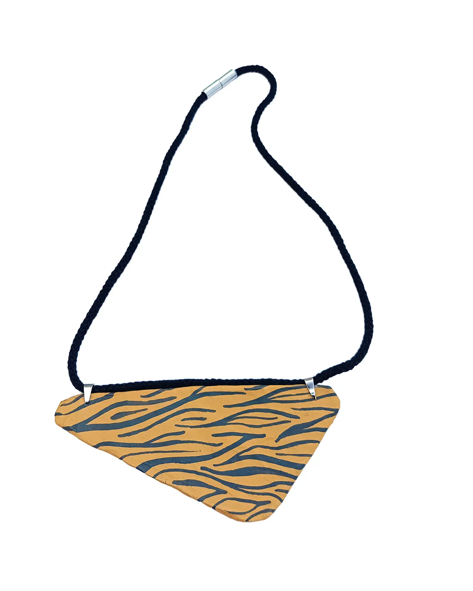 Colgante Atacama en papel maché, forma triangular con fondo ocre y estampado cebra marrón oscuro, sobre fondo blanco.